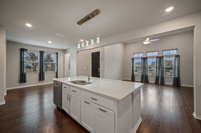 kitchen with dark wood-style floors, stainless steel dishwasher, open floor plan, and a sink