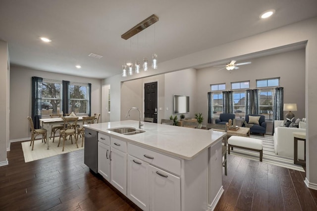 305 Bolivar Way Unit 101, San Marcos, TX 78666 - kitchen with stainless steel dishwasher, white cabinetry, ceiling fan, hanging light fixtures, and dark wood-style floors