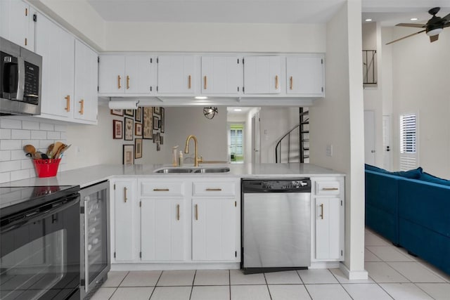 kitchen featuring light countertops, appliances with stainless steel finishes, wine cooler, and a sink