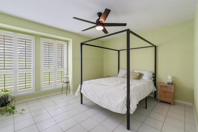 tiled bedroom featuring ceiling fan and baseboards