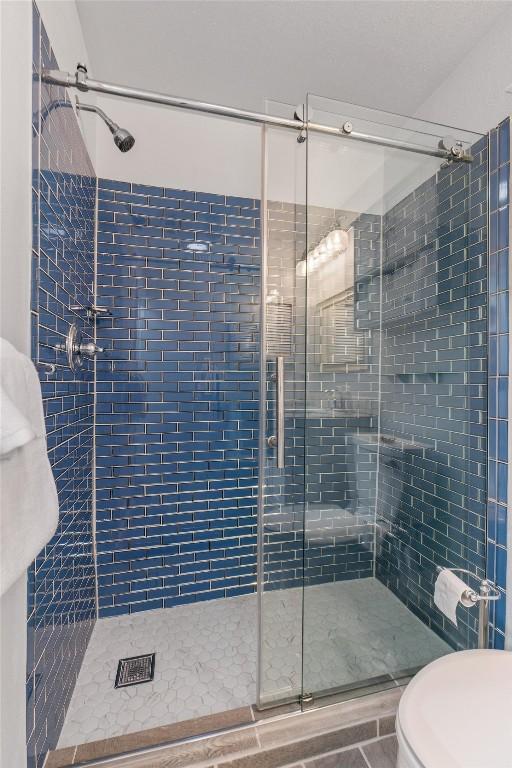 full bathroom with a shower stall and toilet