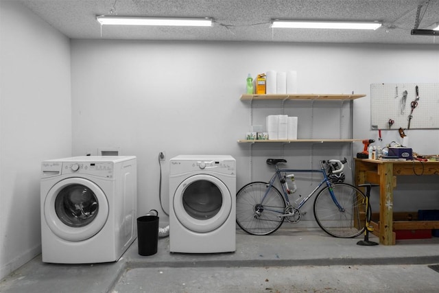 clothes washing area featuring laundry area, a workshop area, and washing machine and clothes dryer