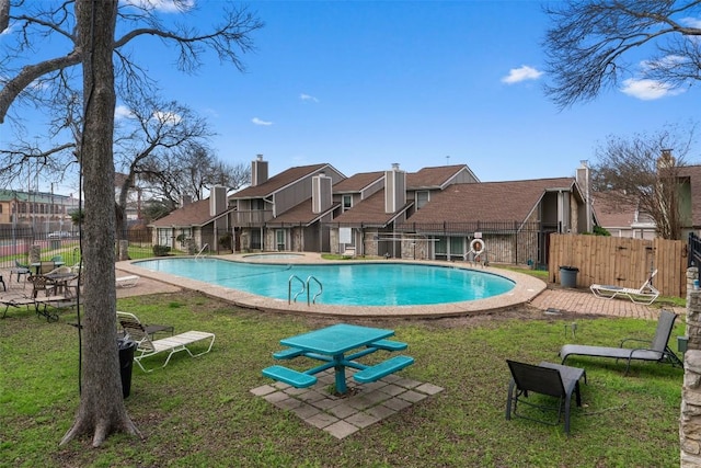 pool featuring a residential view, fence, and a lawn