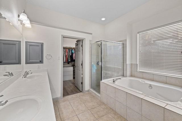 full bath featuring a sink, a walk in closet, and a shower stall