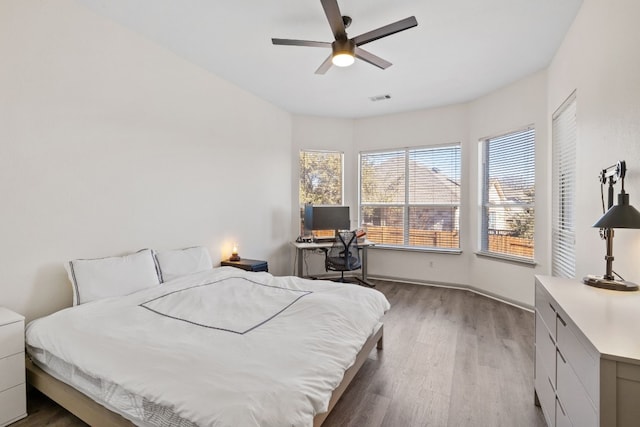 bedroom with visible vents, ceiling fan, baseboards, and wood finished floors