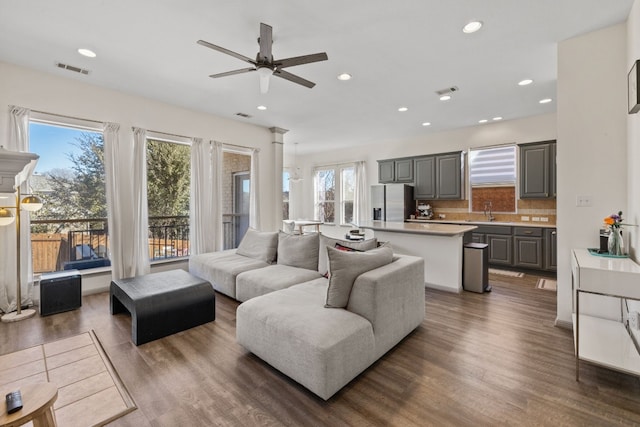 living room featuring ceiling fan, wood finished floors, visible vents, and recessed lighting