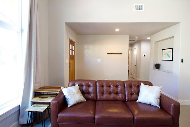 living area with recessed lighting, visible vents, and baseboards