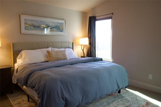 bedroom featuring vaulted ceiling and baseboards