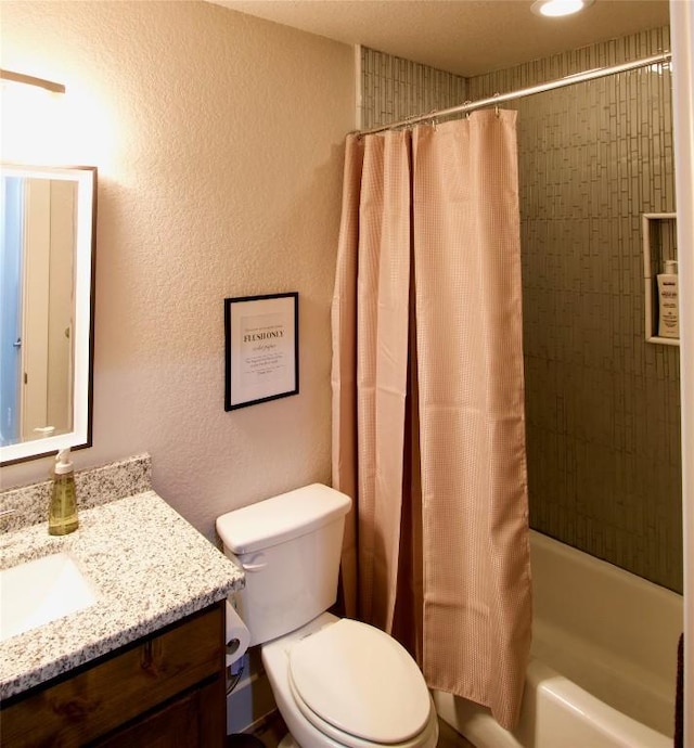 bathroom with toilet, shower / tub combo, a textured wall, and vanity