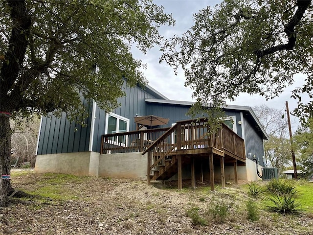 rear view of property with cooling unit, stairway, and a wooden deck