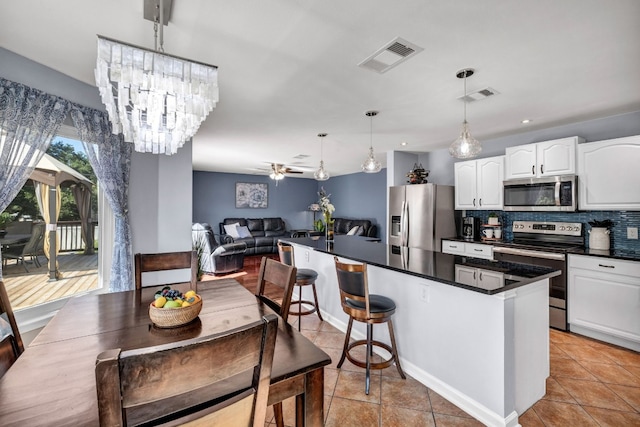 kitchen with dark countertops, visible vents, stainless steel appliances, and white cabinets