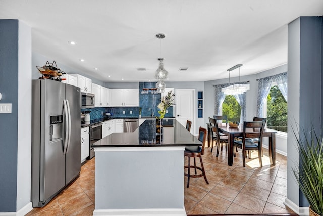 15401 Montoya Cv, Austin, TX 78717 - kitchen featuring stainless steel appliances, dark countertops, white cabinetry, light tile patterned floors, and a sink