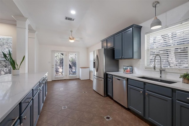 kitchen with appliances with stainless steel finishes, a sink, visible vents, and decorative backsplash