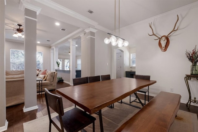 dining space with decorative columns, visible vents, ceiling fan, and wood finished floors