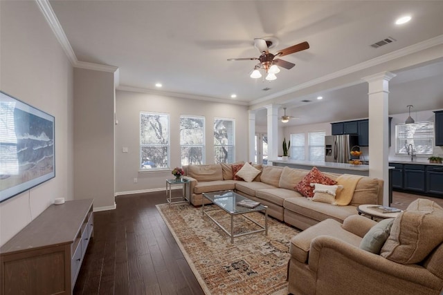 living room featuring dark wood finished floors, visible vents, decorative columns, and baseboards