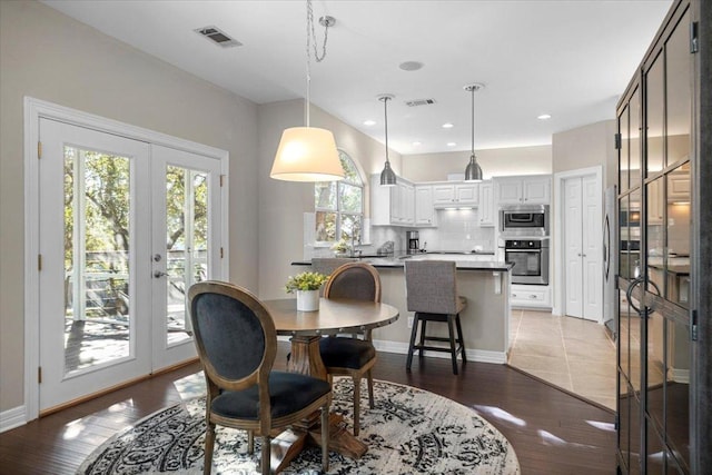 dining area featuring visible vents, wood finished floors, and french doors