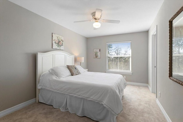 bedroom featuring light carpet, ceiling fan, and baseboards