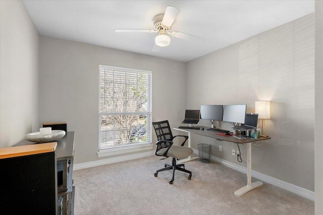 carpeted office with a ceiling fan and baseboards