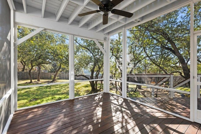 unfurnished sunroom with beamed ceiling and a ceiling fan