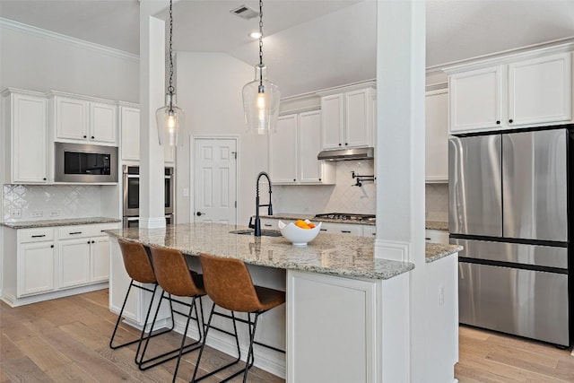 kitchen with visible vents, white cabinets, stainless steel appliances, light wood-type flooring, and under cabinet range hood