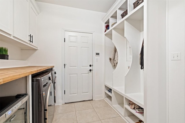 mudroom featuring light tile patterned flooring and washing machine and clothes dryer