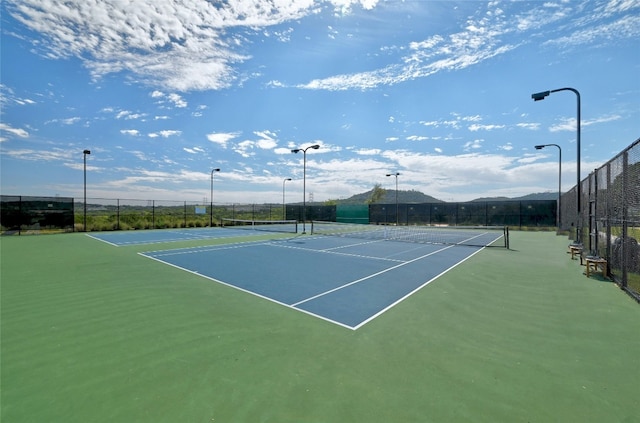 view of tennis court featuring fence