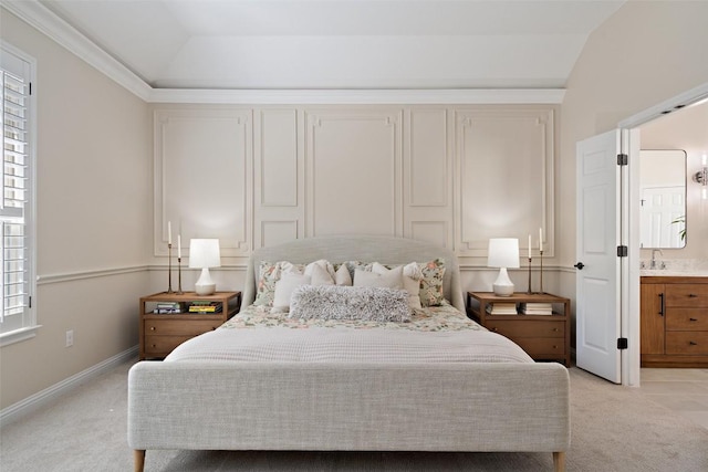 bedroom featuring light carpet, vaulted ceiling, a sink, and baseboards