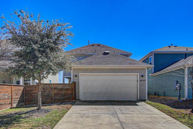 view of front of home with a garage, fence, and concrete driveway