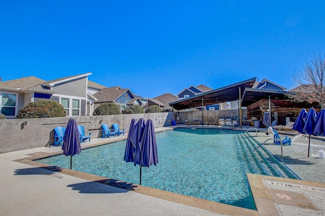 community pool featuring a fenced backyard and a patio