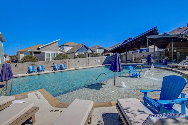 community pool featuring a patio area and a fenced backyard