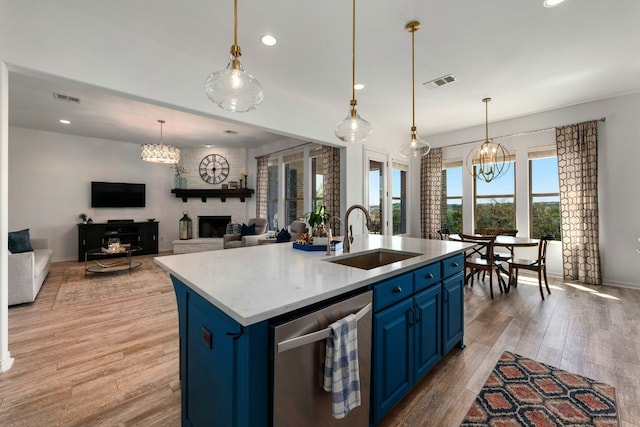 kitchen featuring a chandelier, blue cabinets, a sink, visible vents, and dishwasher