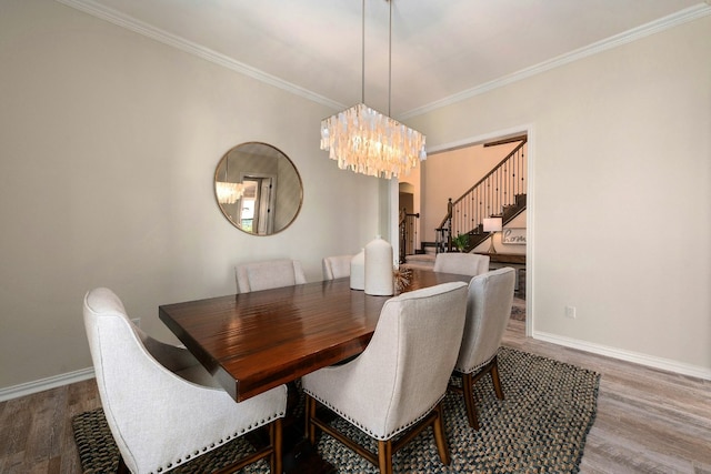 dining room with baseboards, wood finished floors, and ornamental molding