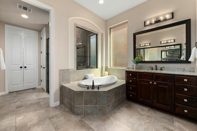 full bath featuring recessed lighting, visible vents, vanity, baseboards, and a bath