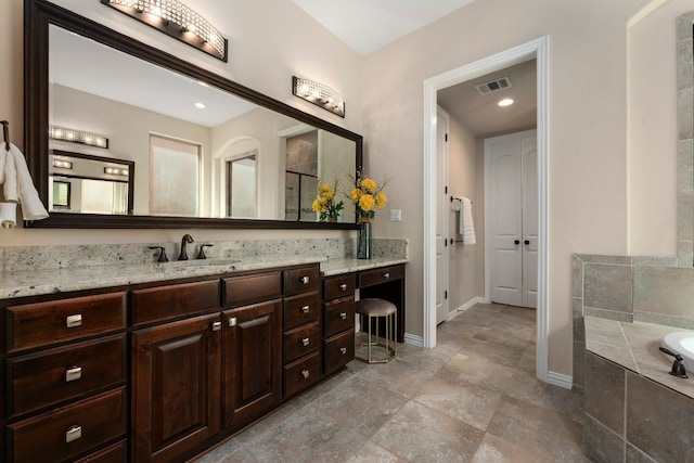 full bathroom with visible vents, a garden tub, vanity, and baseboards