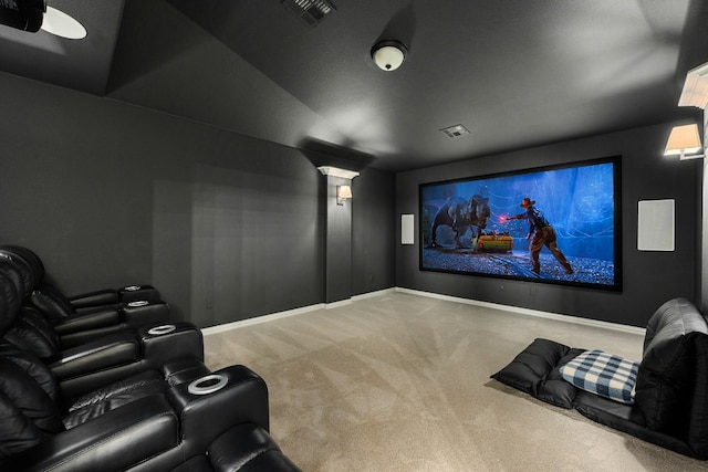 carpeted home theater with vaulted ceiling, visible vents, and baseboards