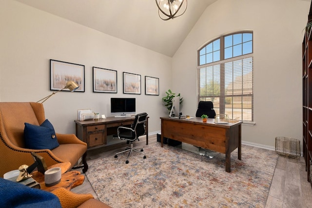 home office featuring an inviting chandelier, baseboards, vaulted ceiling, and wood finished floors