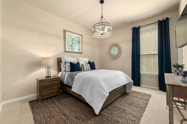 carpeted bedroom with a chandelier and baseboards