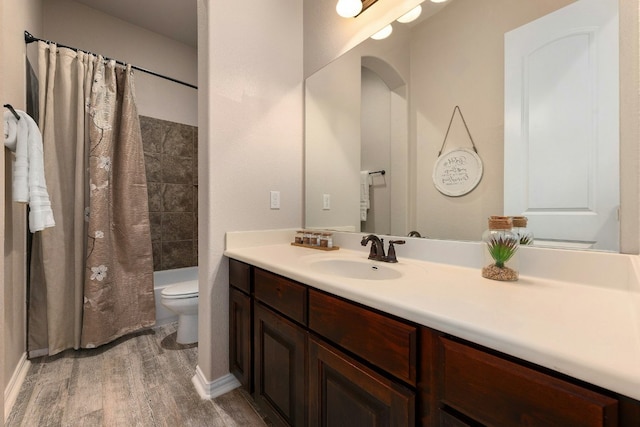 bathroom featuring vanity, shower / bath combination with curtain, wood finished floors, and toilet