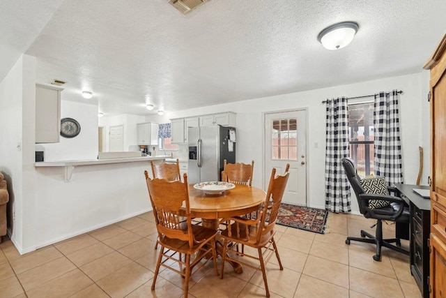 402 Laurel St, Bastrop, TX 78602 - dining room with light tile patterned flooring, a textured ceiling, a desk, and baseboards