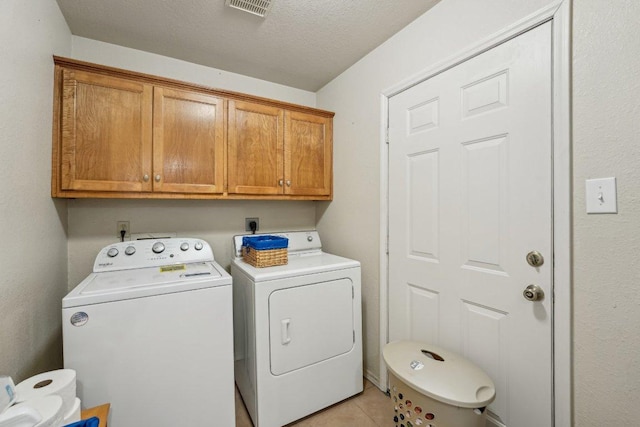 402 Laurel St, Bastrop, TX 78602 - laundry area featuring cabinet space, washer and dryer, light tile patterned flooring, and a textured ceiling