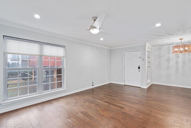 unfurnished room with ornamental molding, baseboards, and wood finished floors