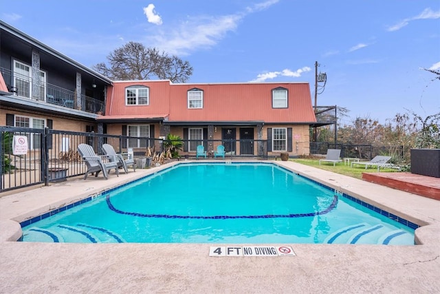 pool with a patio and fence