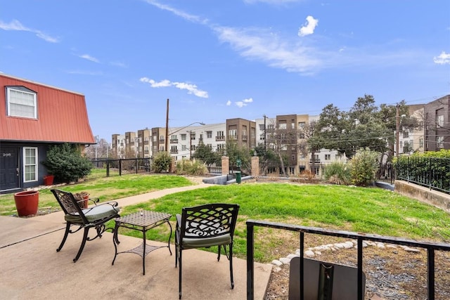 view of property's community with a residential view, fence, and a lawn