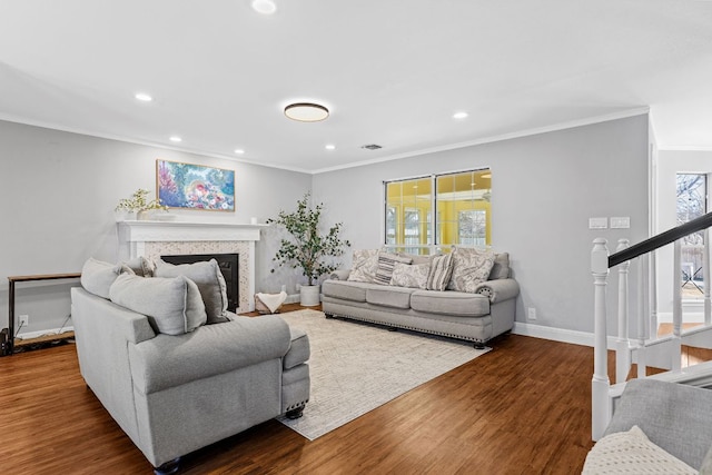 living area featuring dark wood-style floors, a wealth of natural light, a fireplace, and stairway