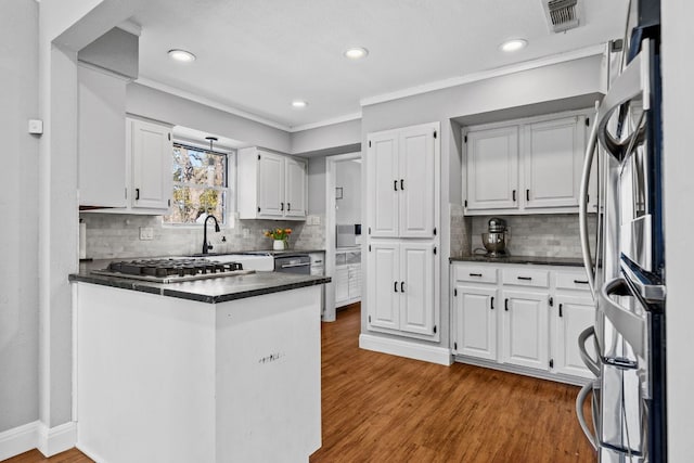 kitchen with wood finished floors, visible vents, white cabinetry, fridge, and dark countertops