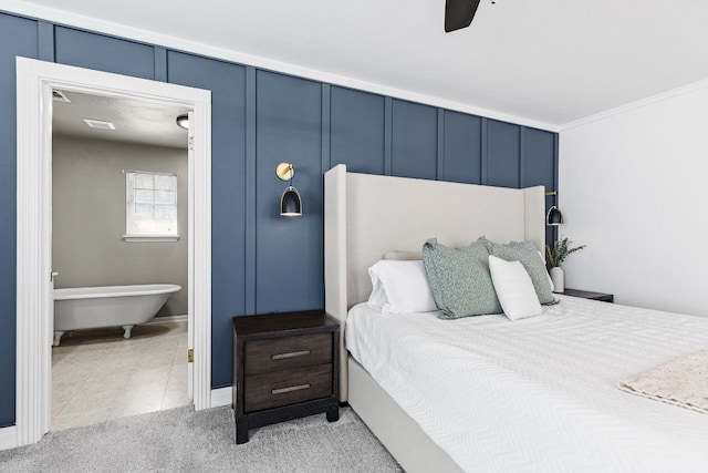 bedroom with light tile patterned floors, a decorative wall, a ceiling fan, and light colored carpet