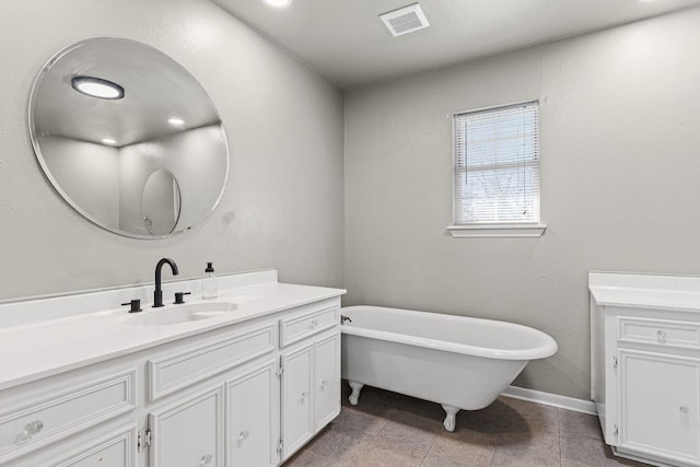 full bath featuring a freestanding tub, baseboards, visible vents, and vanity