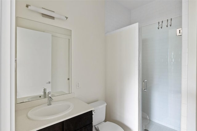 full bath featuring vanity, a shower stall, and toilet