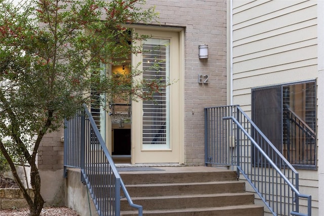 entrance to property featuring brick siding