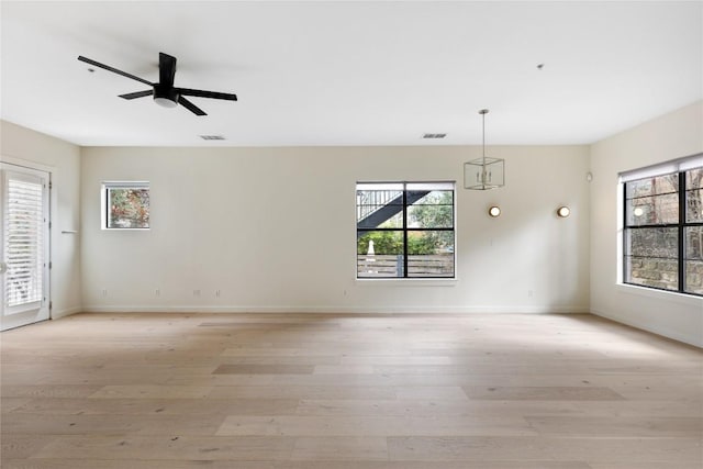 spare room with ceiling fan, a wealth of natural light, and light wood-style flooring